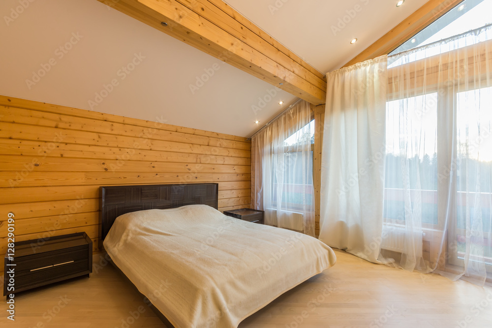 Bedroom with bed, bedside tables, vaulted ceiling, windows with window coverings Bedroom with bed, bedside tables, vaulted ceiling, windows with window coverings