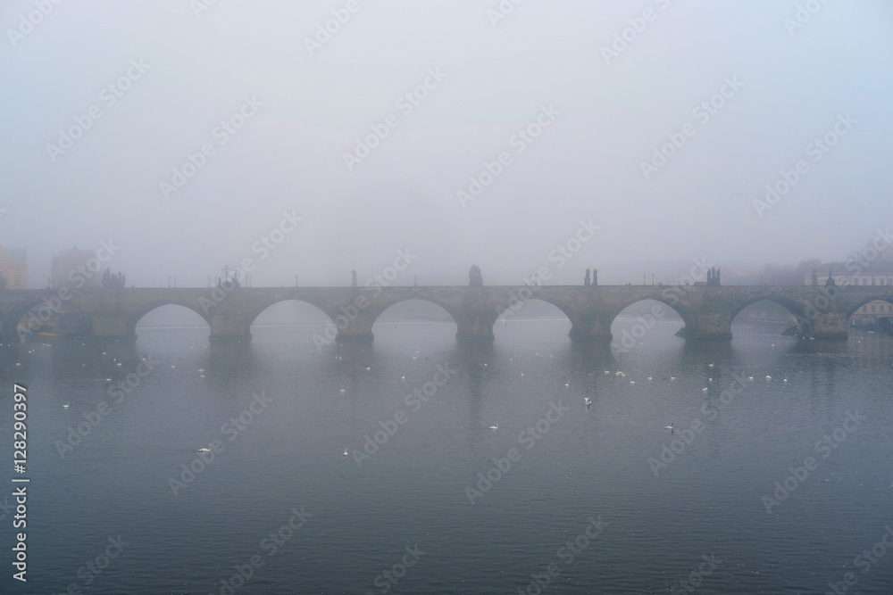 Prague, Czechia - November, 21, 2016: morning fog on Vltava river in Prague, Czechia. There is Charles Bridge in the background.