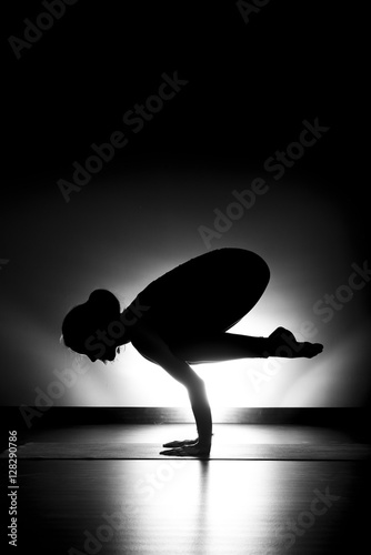 Woman doing yoga crow pose silhouette black and white