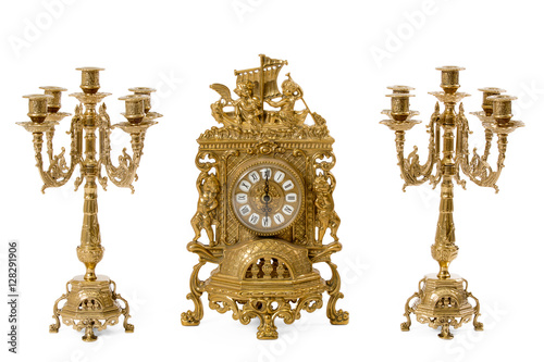 Two vintage gold candle holder and clock on a white background
