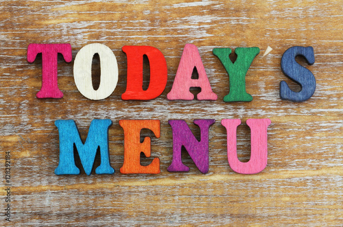 Today's menu written with colorful letters on rustic wooden surface
