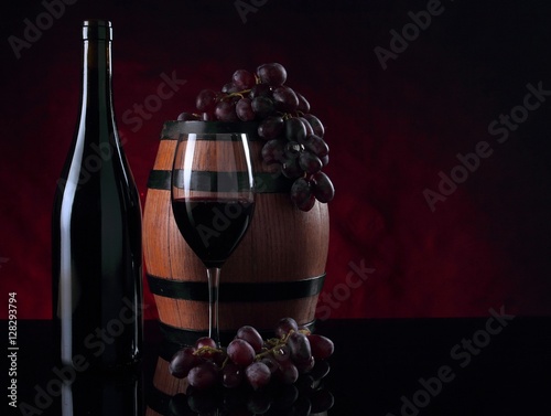 Bottle of vine, barrel, vineglass and grapes photo