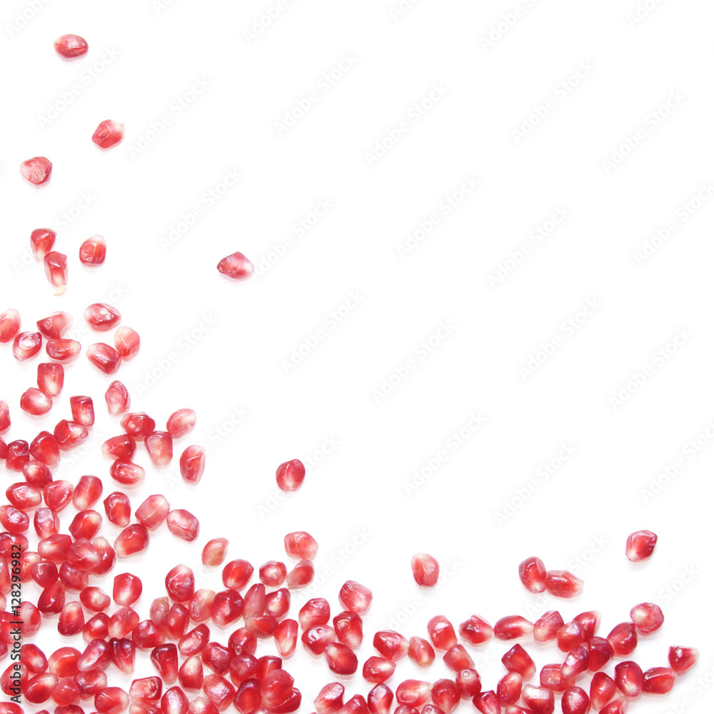 White background with red pomegranate (garnet) seeds