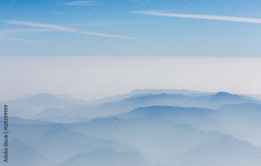 aerial view of layers of mountains covered with clouds