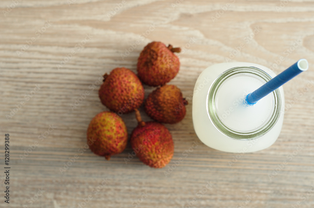 Litchi juice in a glass bottle with a blue straw Litchi juice in a glass bottle with a blue straw