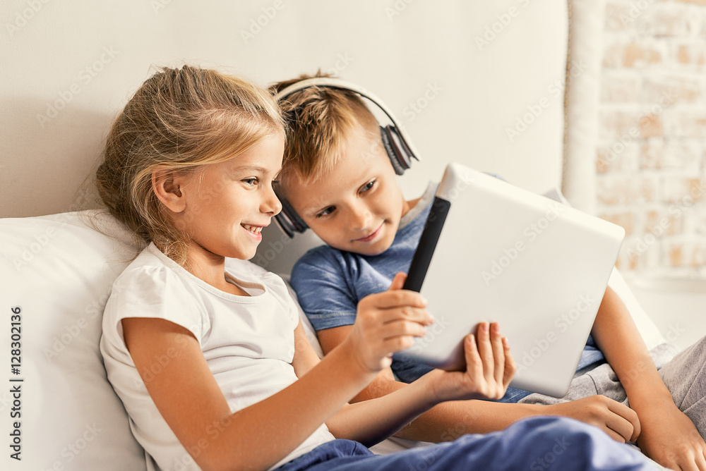 Cute brother and sister enjoying tablet at home Cute brother and sister enjoying tablet at home