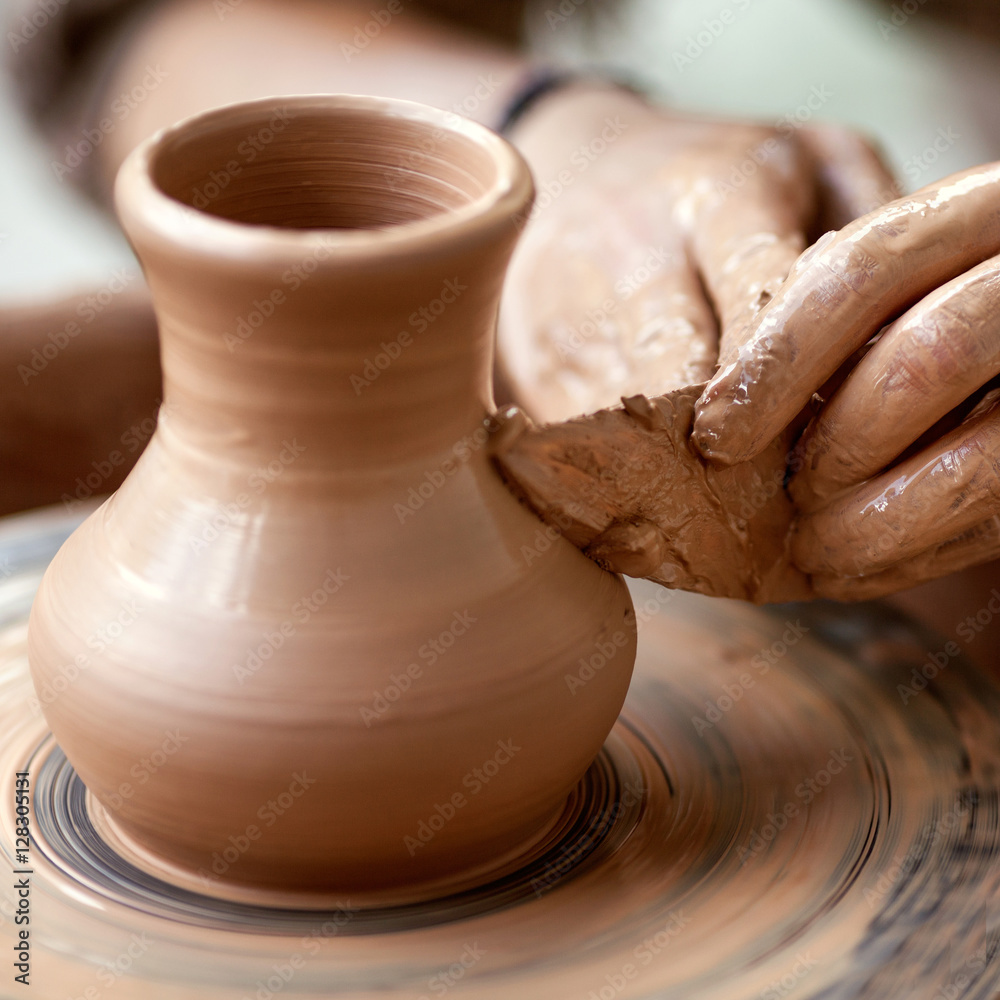 Hands working on pottery wheel Hands working on pottery wheel