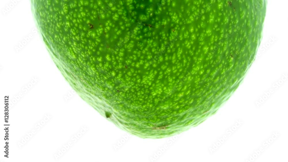 Green avocado suspended in the air rotates in loop Green avocado suspended in the air rotates in loop