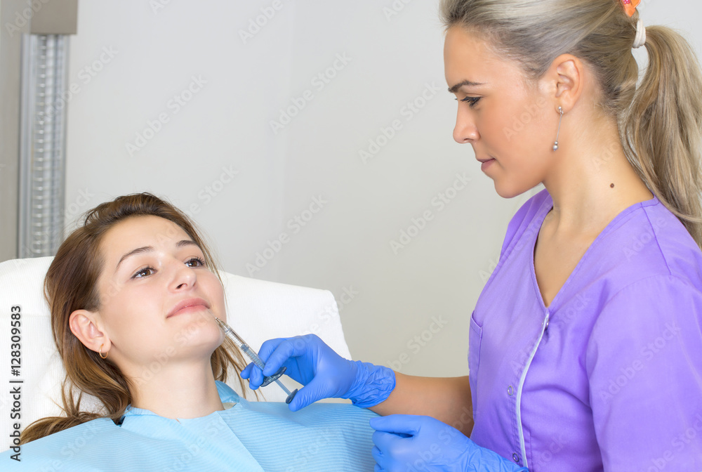 Young Woman Geting an Injection in her Lips in Beauty salon.