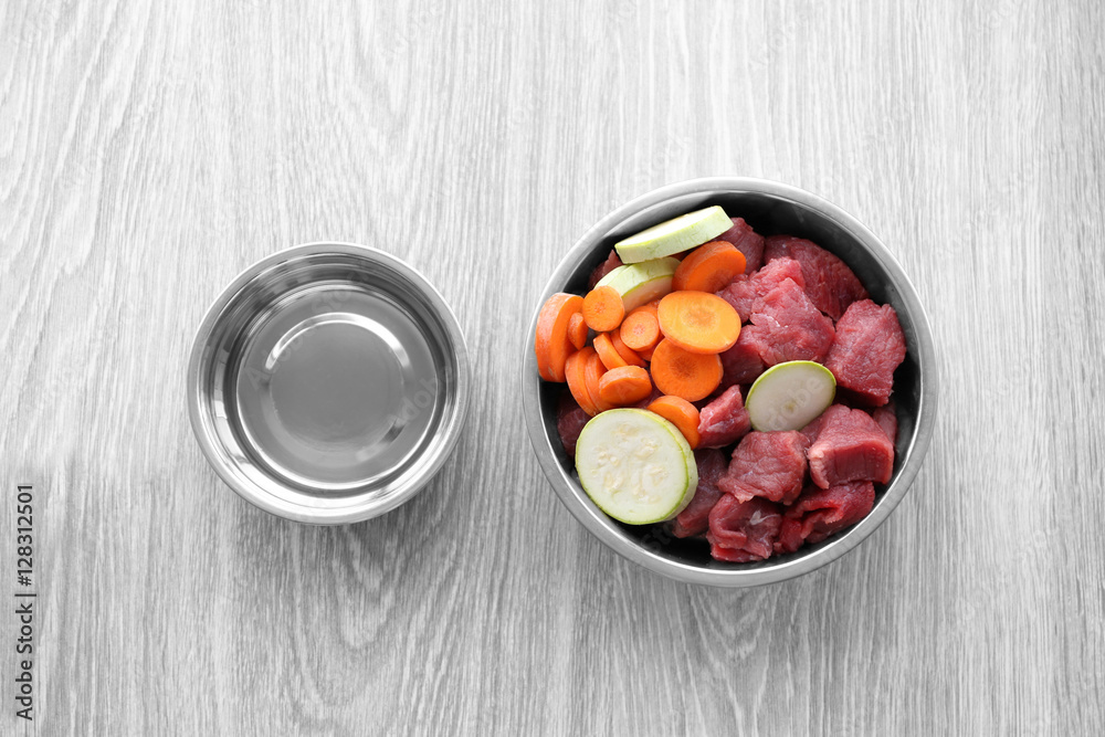 Organic dog food in a bowl on a wooden floor Organic dog food in a bowl on a wooden floor