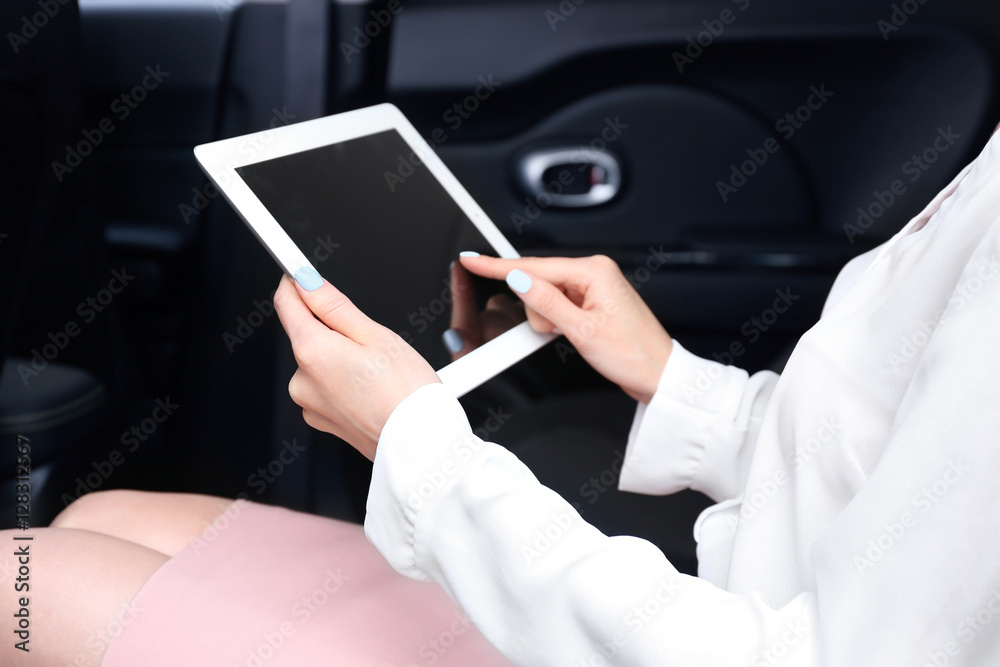 Businesswoman with tablet in a car Businesswoman with tablet in a car