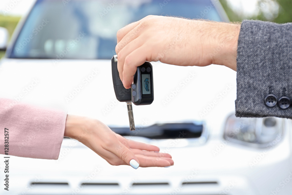 Man giving car key to woman, close up