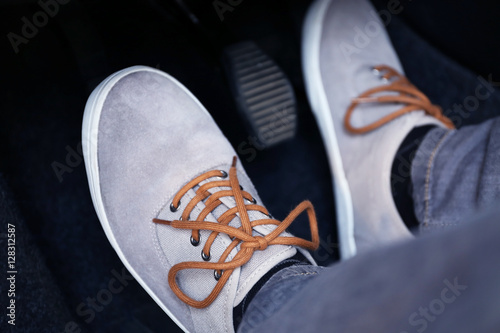 Human feet pressing car pedal