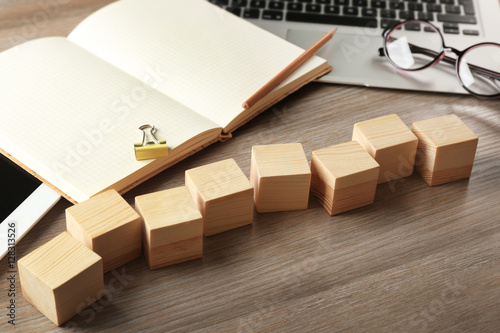 Copybook and wooden cubes on color background