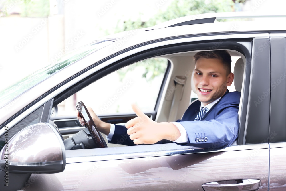 Young businessman looking from car window