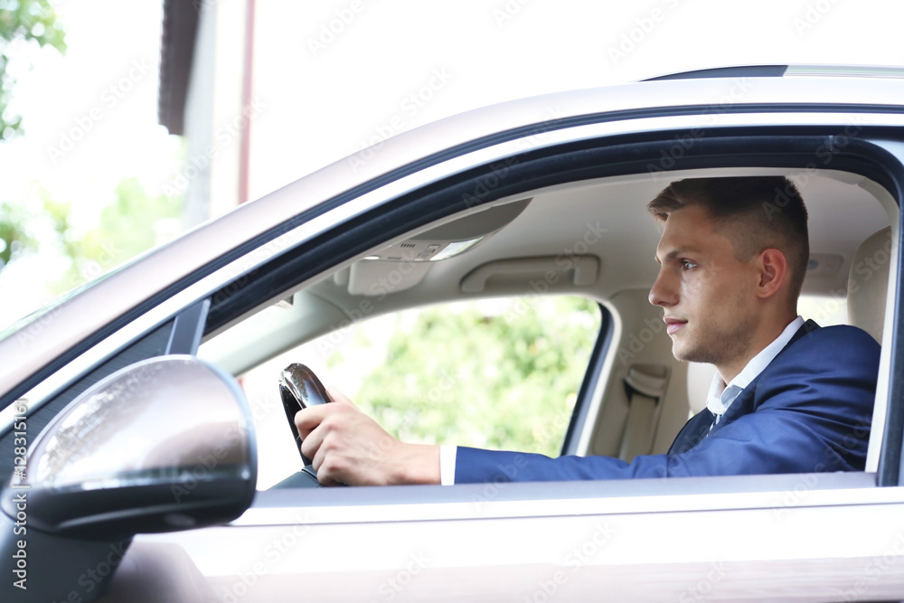 Young businessman driving car