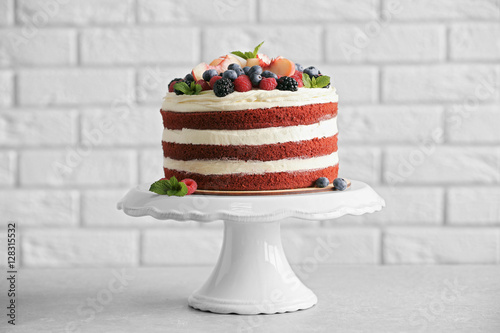 Delicious cake with fruit and berries decoration on gray table