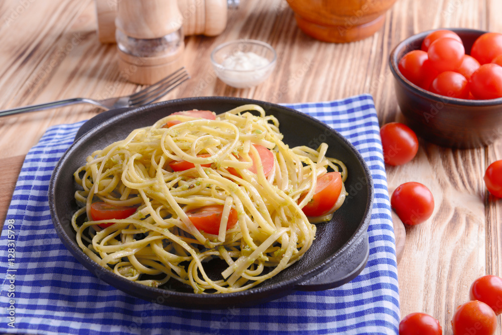 Pasta with cherry tomatoes and avocado sauce on wooden table closeup Pasta with cherry tomatoes and avocado sauce on wooden table closeup