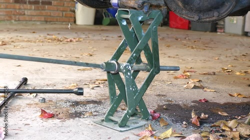 Scissor Style Jack Raising And Lowering An Axle  photo