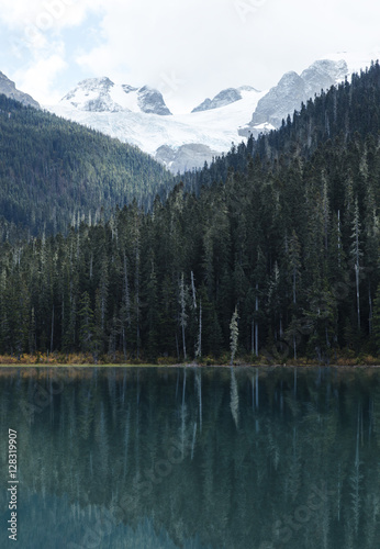 Joffre lakes provincial park Vancouver, British Columbia Canada. Glacial Mountains covered in snow with lake reflection. Evergreen forest reflection. Pacific North West.  © kaiyhun