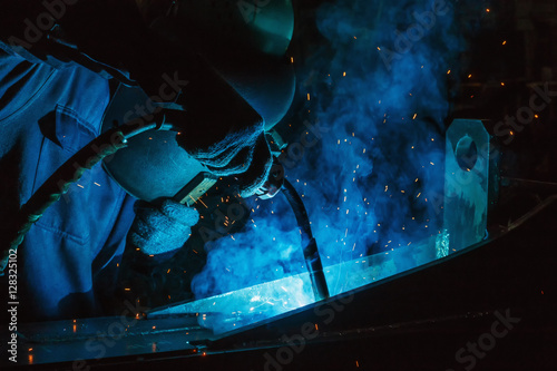 Welder of Metal Welding with sparks in industry steel weld