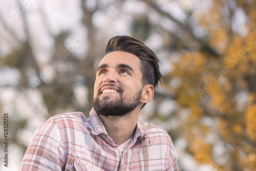 Young man smiling looking up head face, close up.