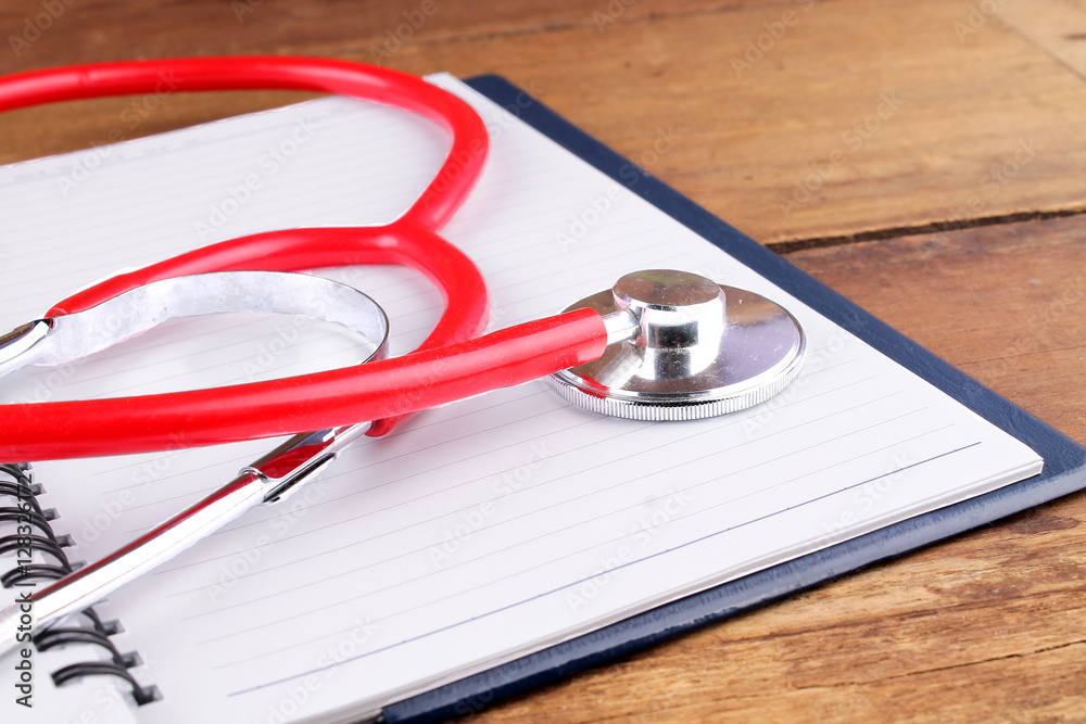Medical concept. Stethoscope and open notebook on wooden background Medical concept. Stethoscope and open notebook on wooden background