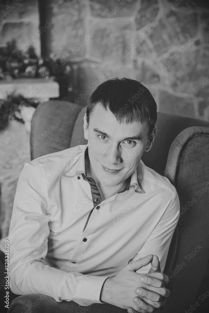 Fototapeta premium young man sitting on background of Christmas interior