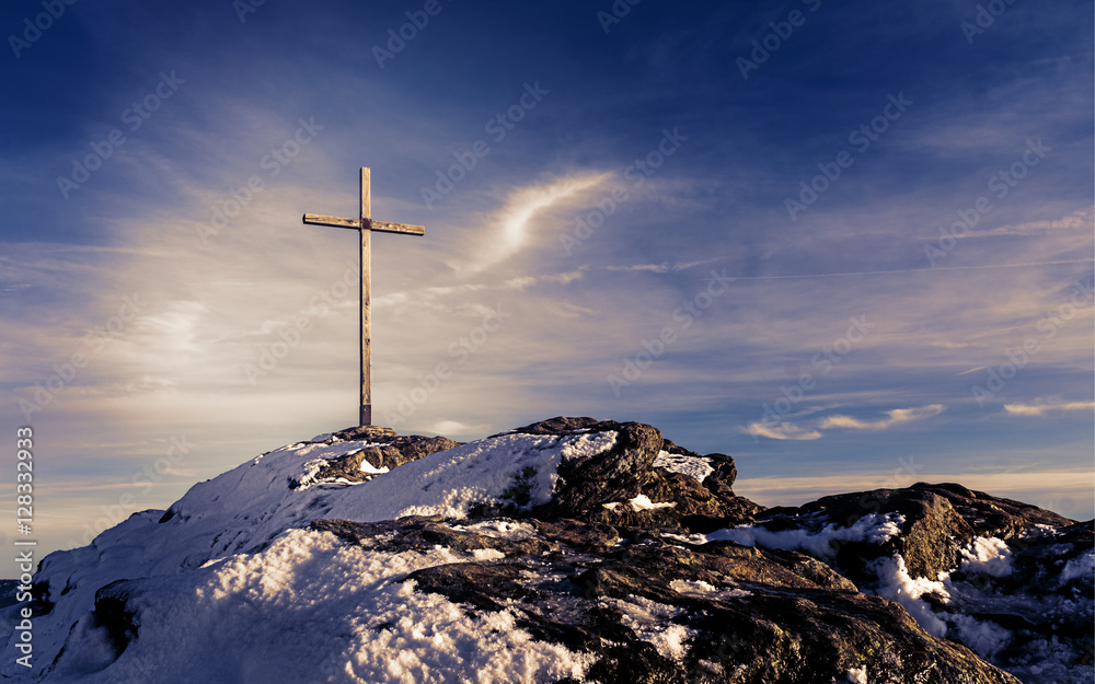 Wooden summit cross on the mountain peak with cloudy clear sky - Picture with mystic purple look
