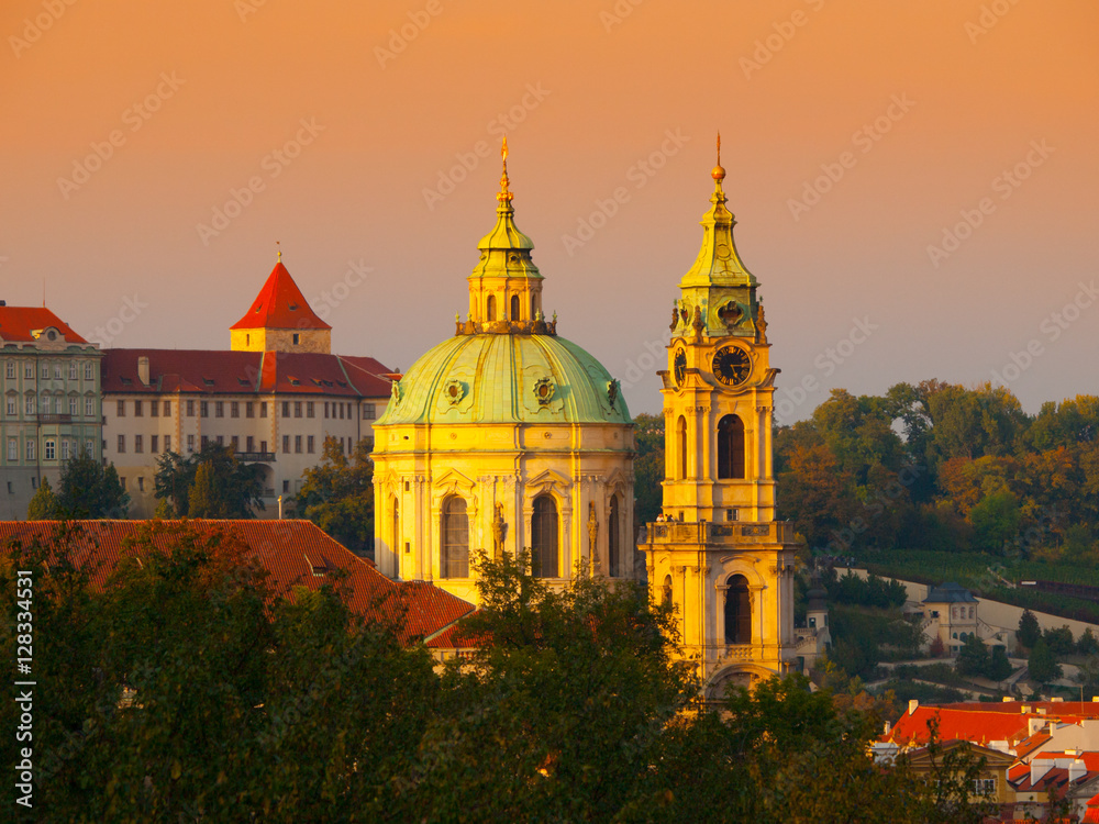 Illuminated dome and tower of St. Nicholas Church in Lesser Town of Prague - capital city of Czech republic, Europe. Evening shot at sunset time. UNESCO World Heritage Site