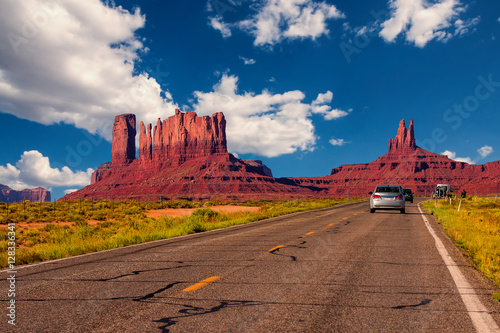 Highway in Monument Valley, Utah / Arizona, USA - Picture with road and cars driving towards the hills. Photo made during a road trip throughout the western states.