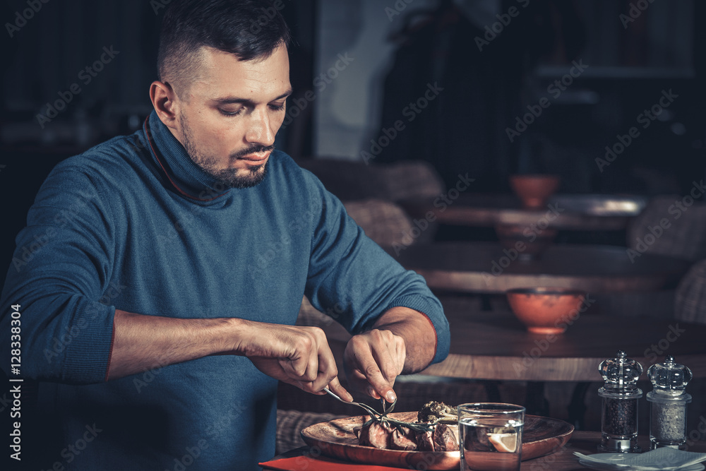 young handsome man eating at the restaurant young handsome man eating at the restaurant