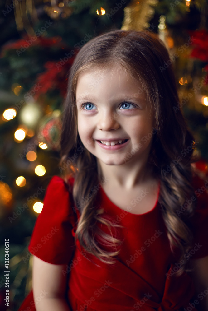 little girl three years in a red dress smiling