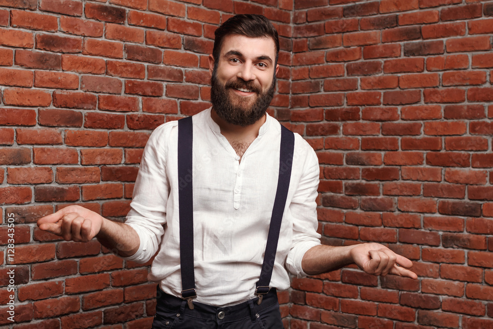Young handsome man smiling gesturing over brick background. Young handsome man smiling gesturing over brick background.