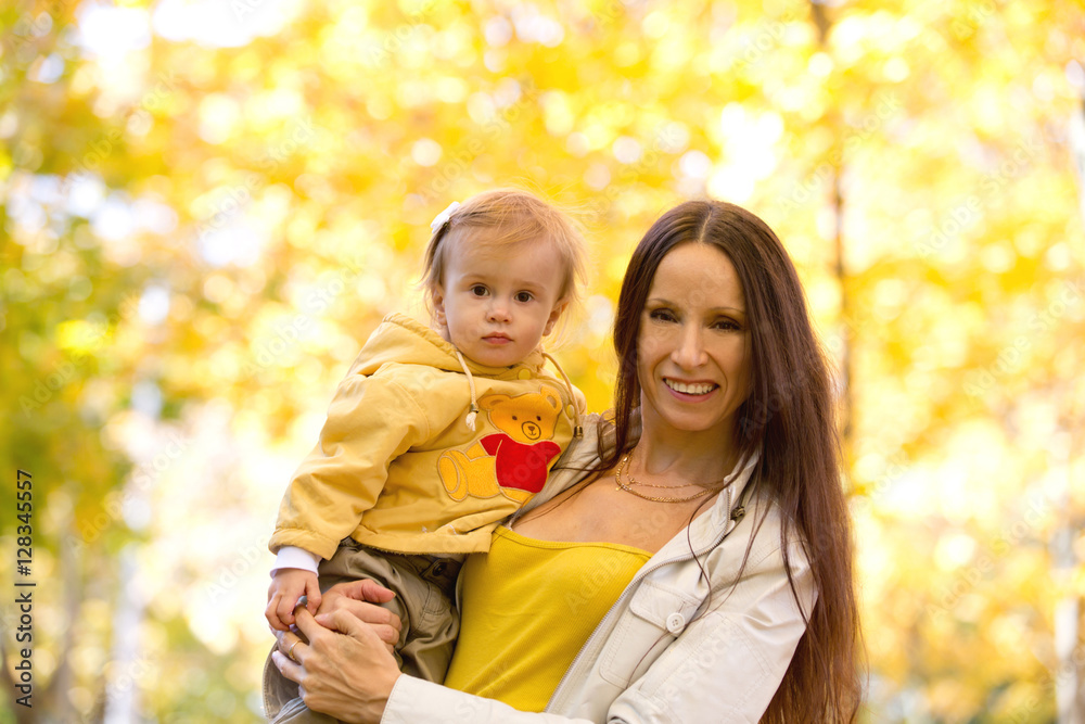 Mother and child playing with leaves in autumn park Mother and child playing with leaves in autumn park