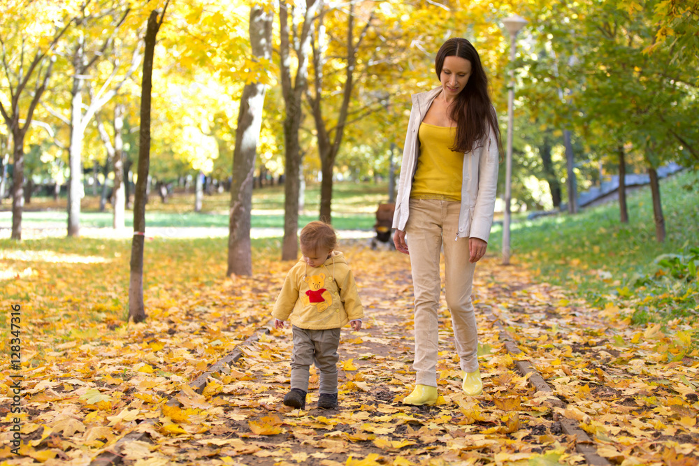 Mother and child playing with leaves in autumn park Mother and child playing with leaves in autumn park