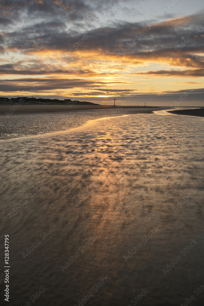 Beautiful beach coastal low tide landscape image at sunrise with Beautiful beach coastal low tide landscape image at sunrise with