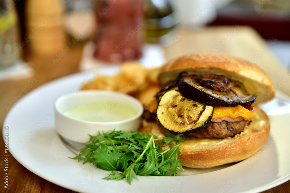 Restaurant food with fresh ingredients - hamburger with cheddar cheese, zucchini, potato slices and tartar sauce