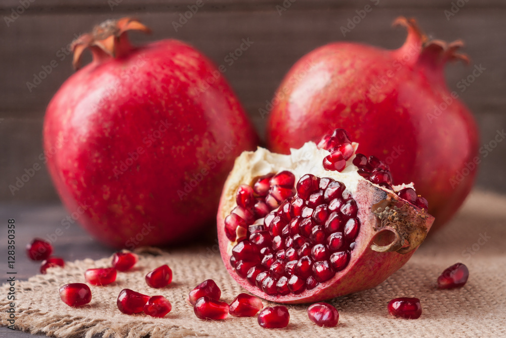 two pomegranate on the old wooden board with sackcloth two pomegranate on the old wooden board with sackcloth