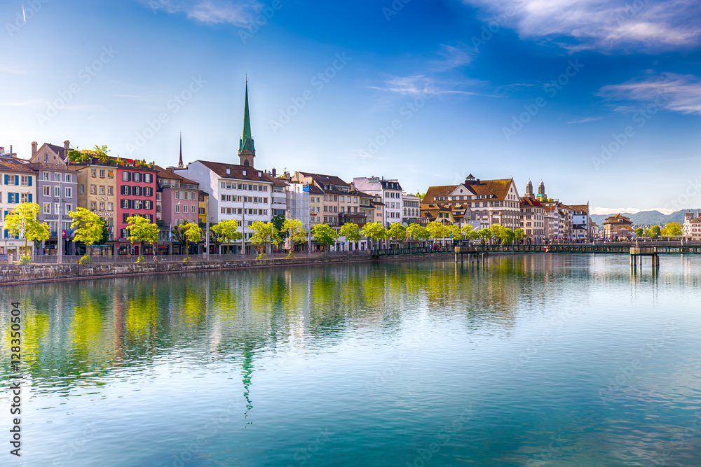 Beautiful view of the historic city center of Zürich with famous Fraumünster Church and swans on river Limmat on a sunny day with blue sky, Canton of Zürich, Switzerland.