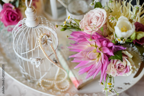 Shabby chic decoration with beautiful vintage birdcage and flowers . Wedding decor idea