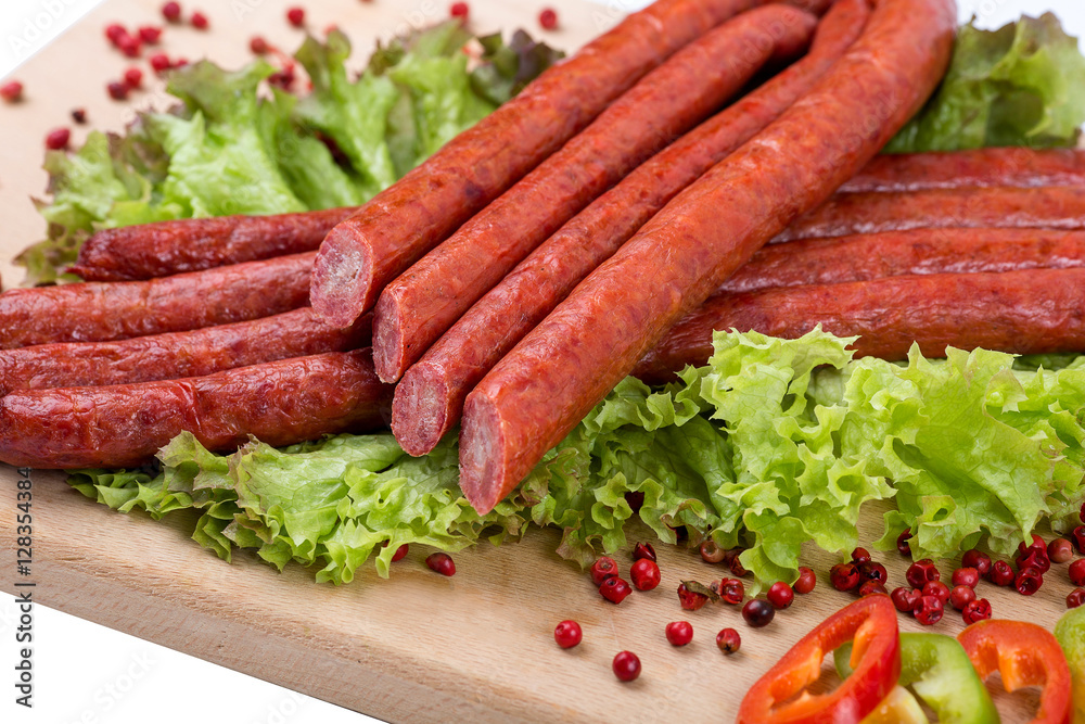Smoked sausages on a kitchen wooden board on white background Smoked sausages on a kitchen wooden board on white background