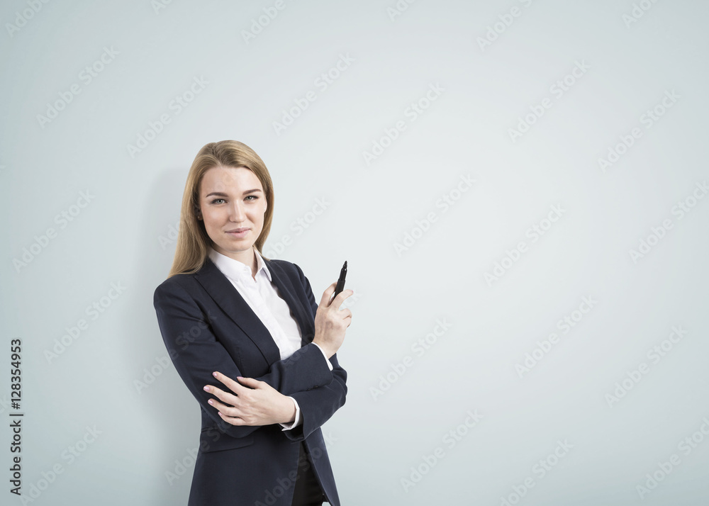 Blond woman with a marker and a gray empty room Blond woman with a marker and a gray empty room