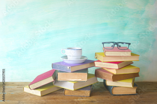 stack of old books with spectacles and cup of coffee, grungy bac