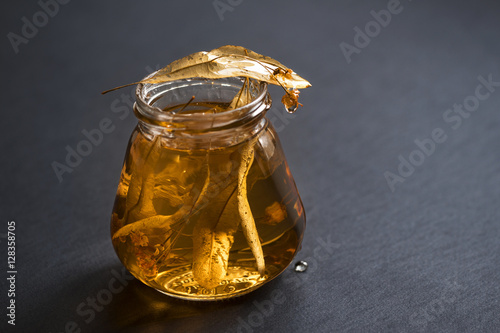 golden linden jam in glass jar with leaves on black desk