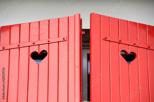 Red, wooden shutters with a heart