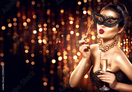 Sexy model woman with glass of champagne wearing venetian masquerade mask