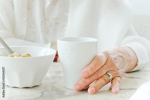 Close up image of senior women with drink  meal time 