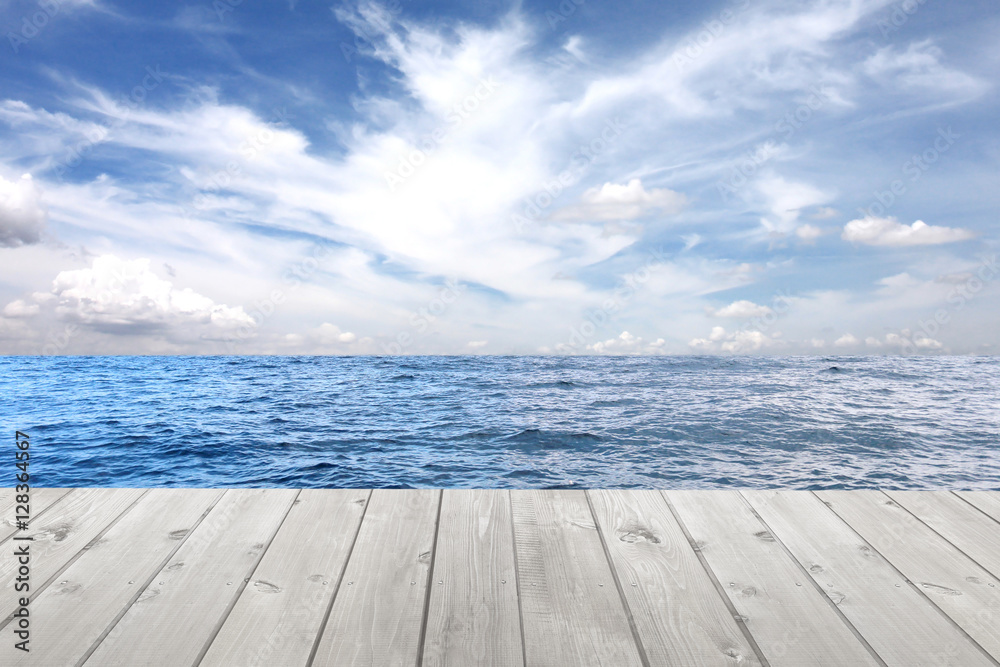 Sea wave and empty wooden floor on blue sky background.
