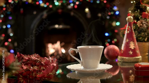 Wallpaper Mural There is a cup of hot tea in a Christmas party on the background of a burning fireplace. Beautiful festive atmosphere Torontodigital.ca